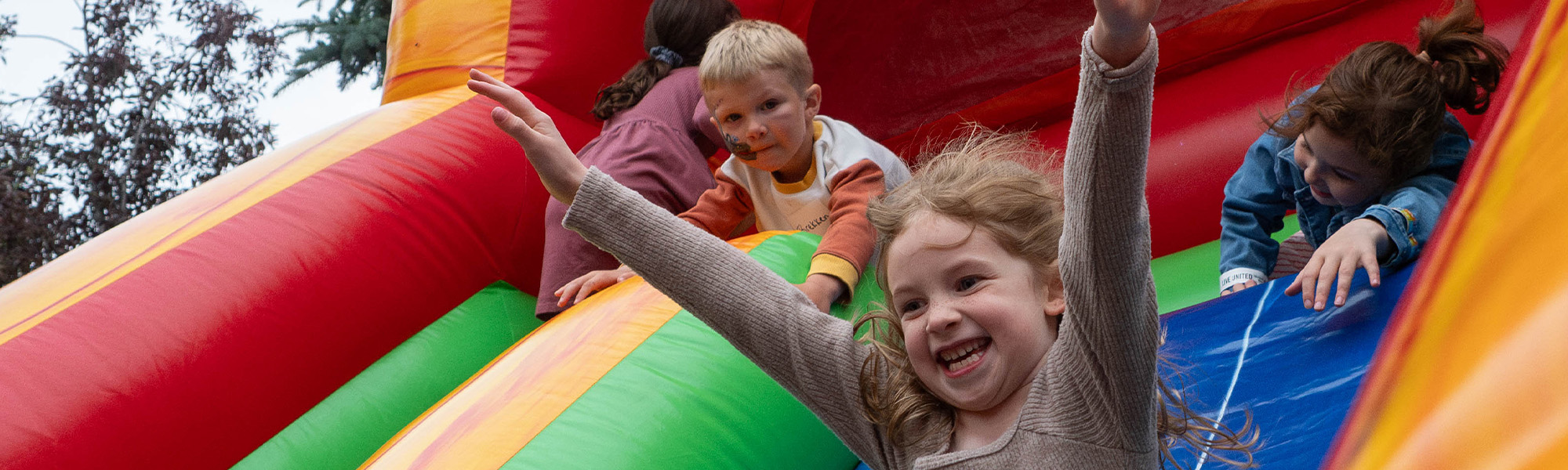 A United Way donor's child slides down an inflatable slide at our Leadership Picnic.