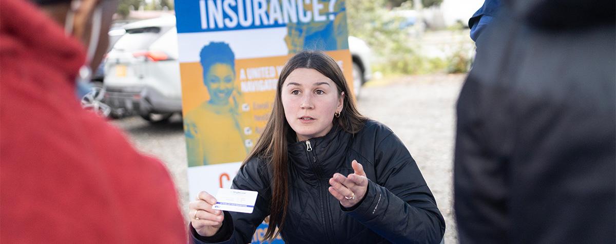 A healthcare navigator talks to Alaskans about health insurance.