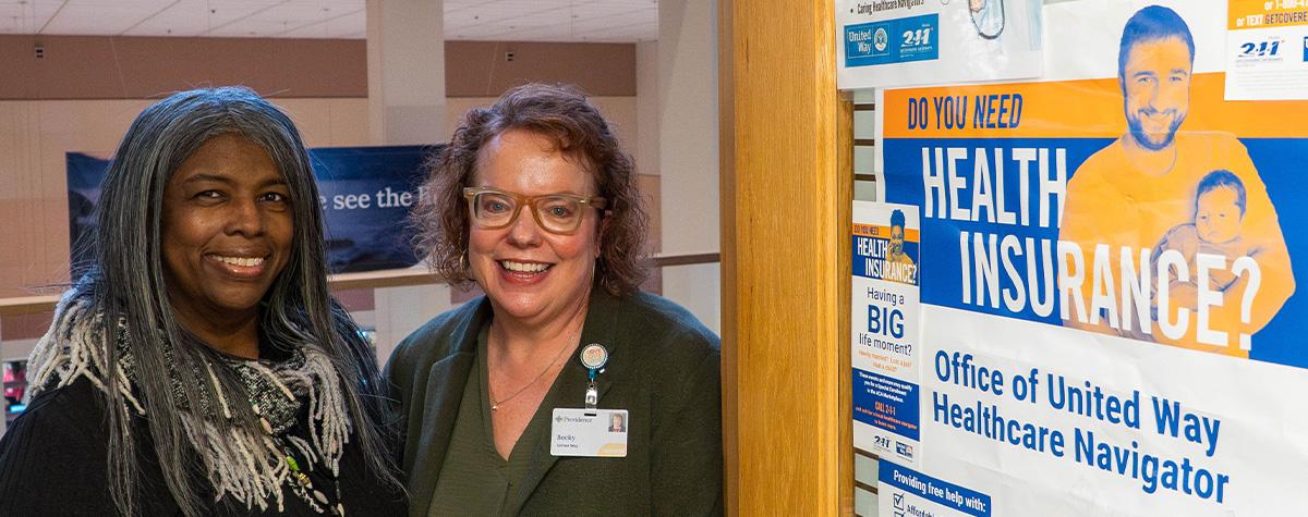 A healthcare navigator and a Providence Alaska employee stand outside the office of United Way's healthcare navigators in the Anchorage hospital.