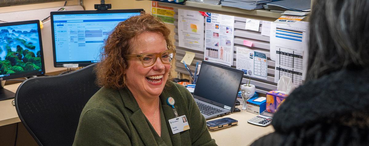 A healthcare navigator discusses health insurance plans with an Alaskan during open enrollment.
