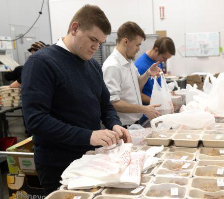 Volunteers pack food to deliver to home-bound Alaskans.