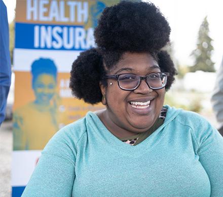 A healthcare navigator meets with people at a health fair.