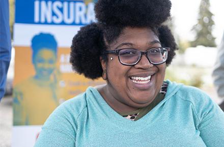 A healthcare navigator meets with people at a health fair.