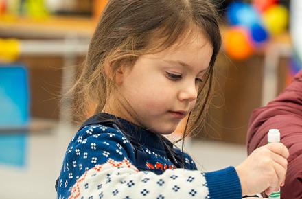 A young child practices their coloring skills in an ASD gymnasium.