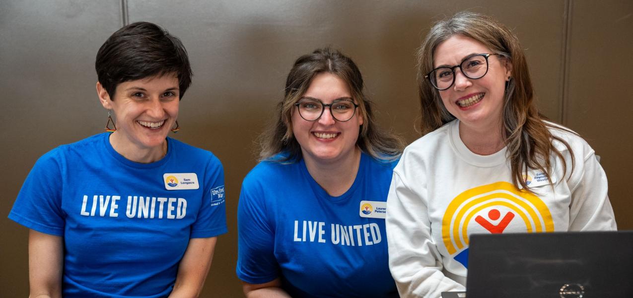 Three United Way of Anchorage staff sitting at an event table