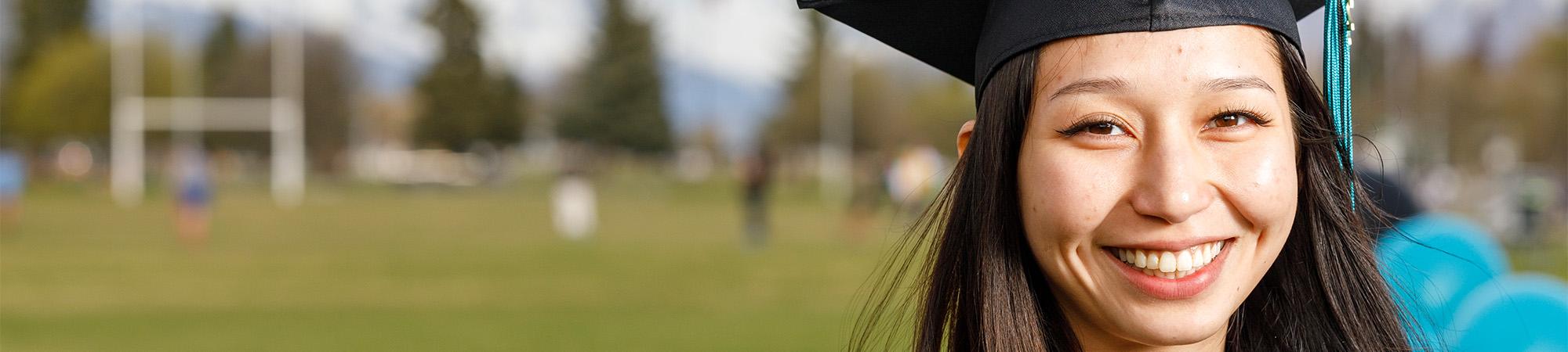 A student in the Anchorage School District walks in her cap and gown after graduation.