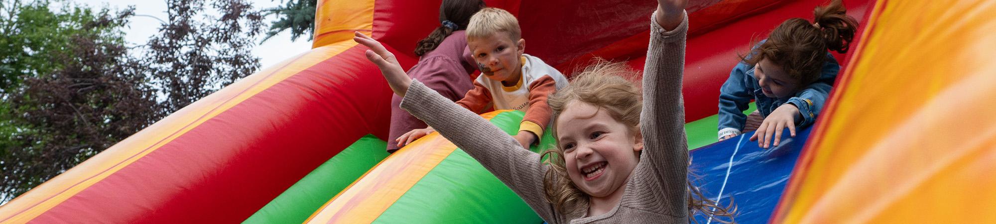 A United Way donor's child slides down an inflatable slide at our Leadership Picnic.