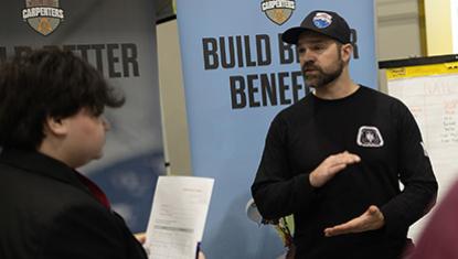 ASD student in conversation with a builder at Academies of Anchorage career expo