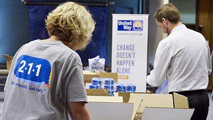 A United Way of Anchorage employee, representing Alaska 211, joins others to prepare materials.